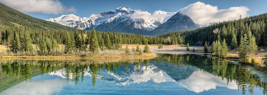 Landscape of a lake with trees and mountains in the background